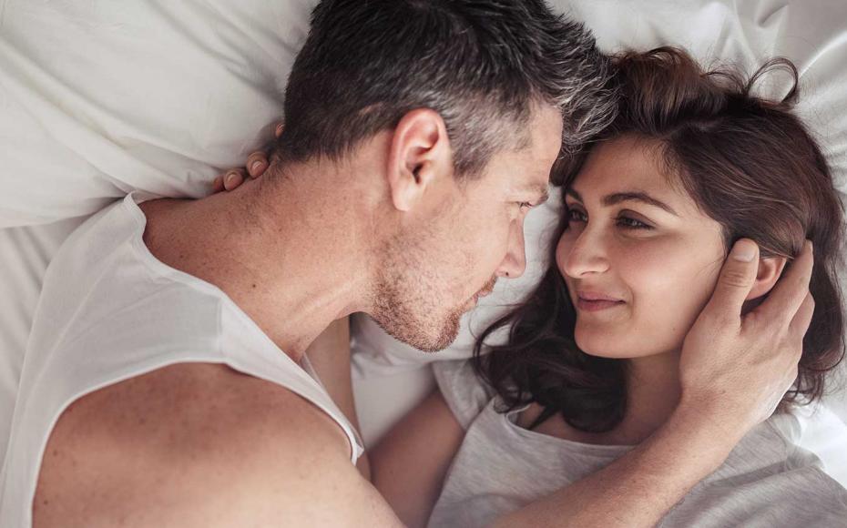 Kvinna och man anstikte mot ansikte i en säng